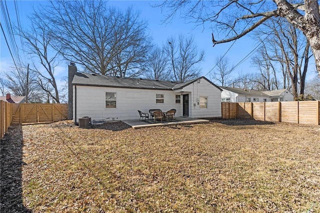 back of house with a chimney, central air condition unit, a gate, a patio area, and a fenced backyard