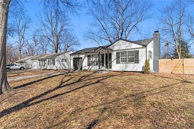 view of front of property with a front yard, fence, and a chimney