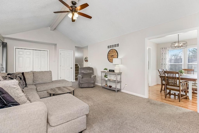 carpeted living area featuring visible vents, lofted ceiling with beams, baseboards, and ceiling fan with notable chandelier