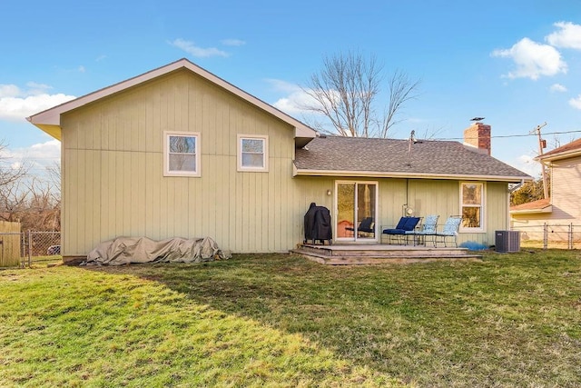 back of house with central air condition unit, a yard, and fence