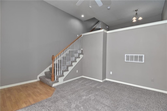 carpeted empty room with stairway, baseboards, and visible vents