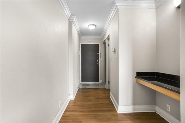 hall with ornamental molding, dark wood-style flooring, and baseboards