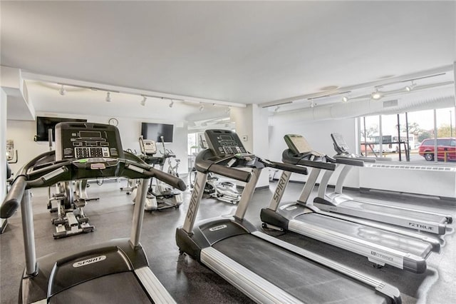 exercise room featuring rail lighting