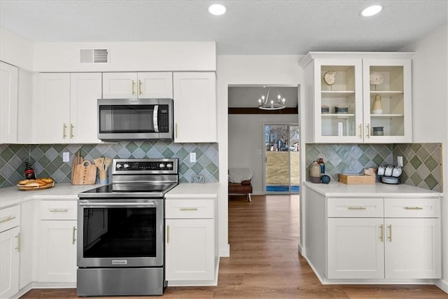 kitchen featuring stainless steel appliances, light countertops, and white cabinetry