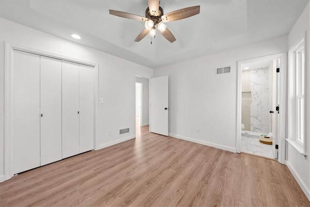 unfurnished bedroom with a closet, visible vents, light wood-style flooring, and baseboards