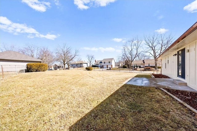 view of yard featuring a residential view, a patio area, and fence