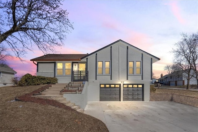 view of front facade with a garage, driveway, and stairs