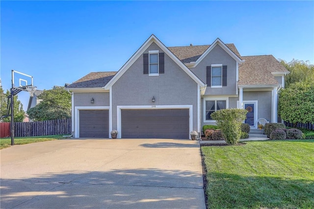 traditional home featuring a front lawn, fence, driveway, and stucco siding