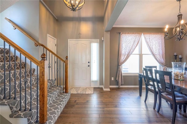 entrance foyer with stairway, baseboards, a chandelier, and dark wood-style flooring