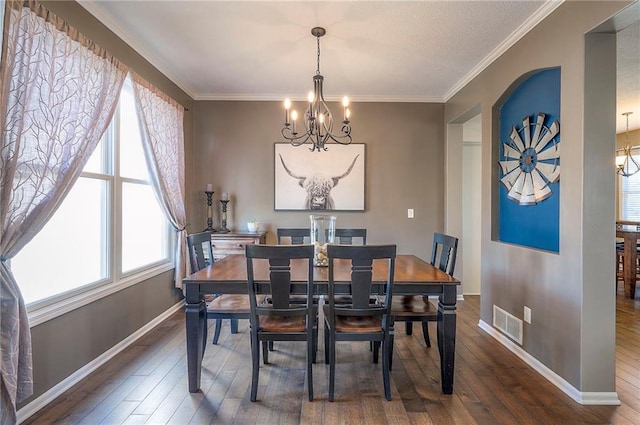 dining area with crown molding, dark wood-style floors, visible vents, and a chandelier