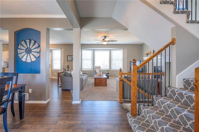 living area with plenty of natural light, wood finished floors, and stairs