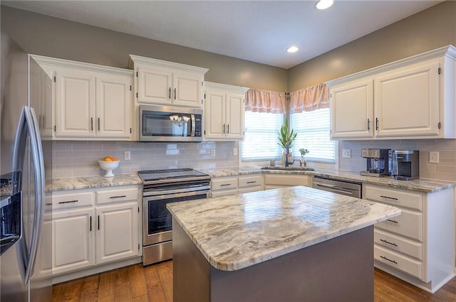 kitchen with dark wood-style floors, appliances with stainless steel finishes, and white cabinetry