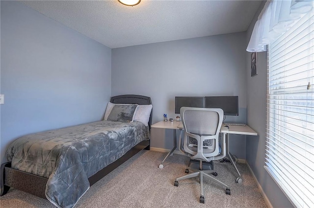 bedroom with carpet flooring, a textured ceiling, and baseboards