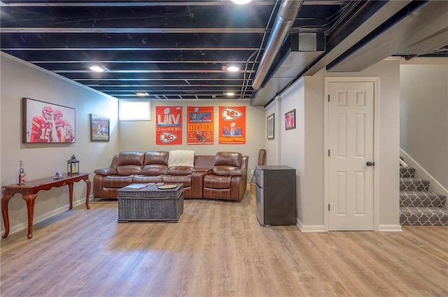 living area featuring stairs, baseboards, and wood finished floors