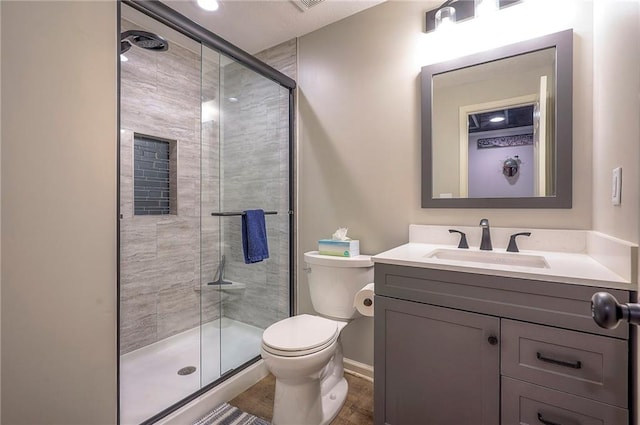 bathroom featuring vanity, toilet, baseboards, and a stall shower