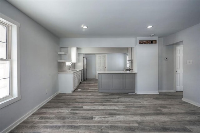 kitchen featuring open shelves, plenty of natural light, light countertops, and a sink