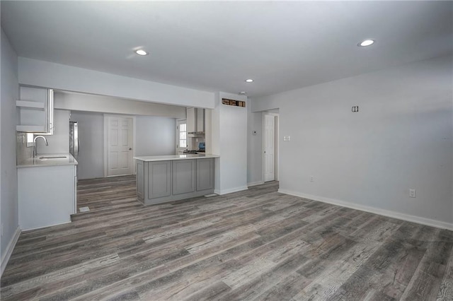 kitchen featuring recessed lighting, dark wood-style flooring, a sink, light countertops, and gray cabinets