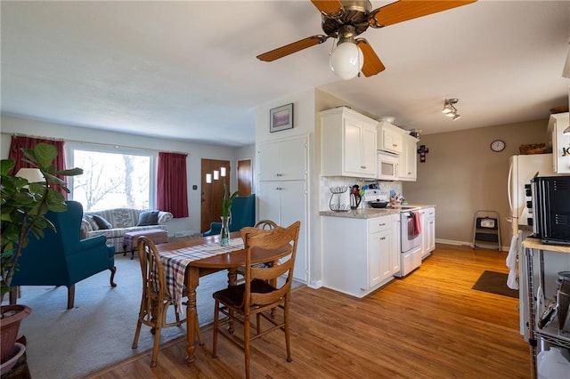 dining room featuring ceiling fan, baseboards, and light wood-style flooring