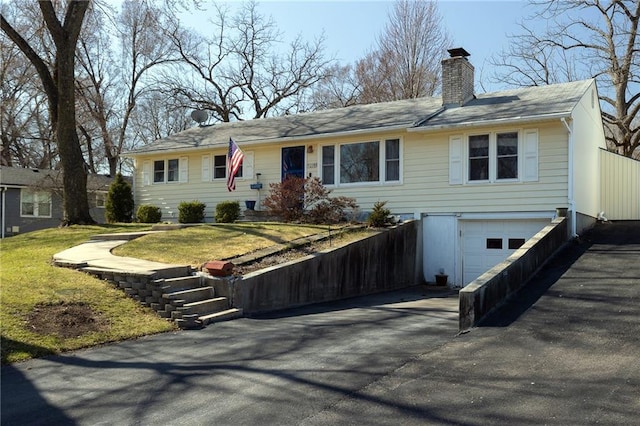 ranch-style home featuring aphalt driveway, a front lawn, a garage, and a chimney