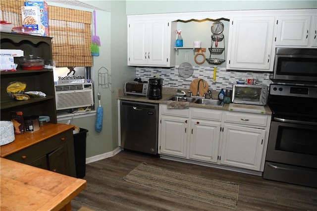 kitchen with a sink, appliances with stainless steel finishes, white cabinets, decorative backsplash, and dark wood-style flooring