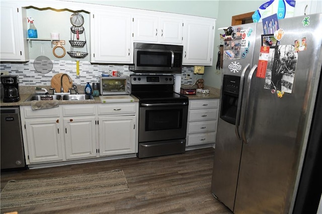 kitchen featuring dark wood finished floors, a sink, white cabinets, appliances with stainless steel finishes, and tasteful backsplash