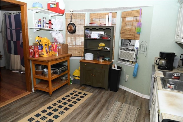 kitchen featuring light countertops, cooling unit, wood finished floors, and baseboards