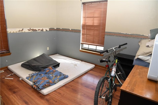 bedroom with baseboards and wood finished floors