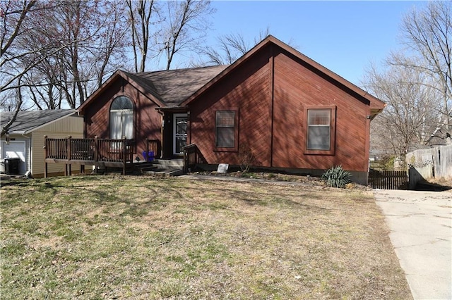 view of front of house featuring a wooden deck, a front yard, and fence