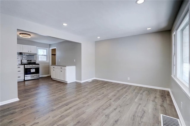 interior space featuring light wood-type flooring, baseboards, and visible vents