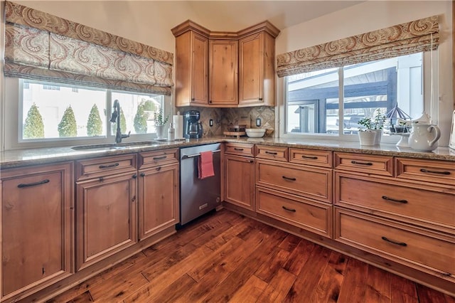 kitchen with a sink, backsplash, brown cabinets, dishwasher, and dark wood finished floors