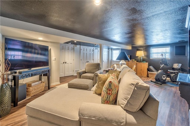 cinema room featuring a wealth of natural light, a textured ceiling, and wood finished floors