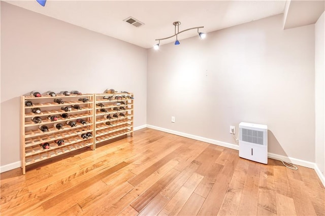 unfurnished room with visible vents, baseboards, and wood finished floors