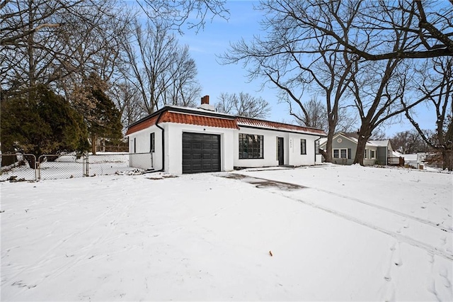 snow covered garage with fence