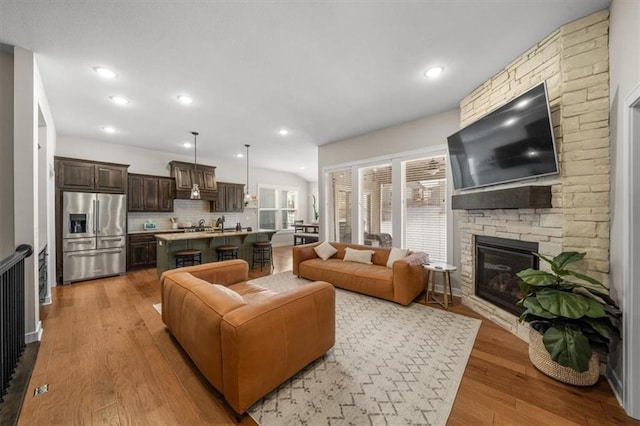 living area with light wood finished floors, a fireplace, and recessed lighting