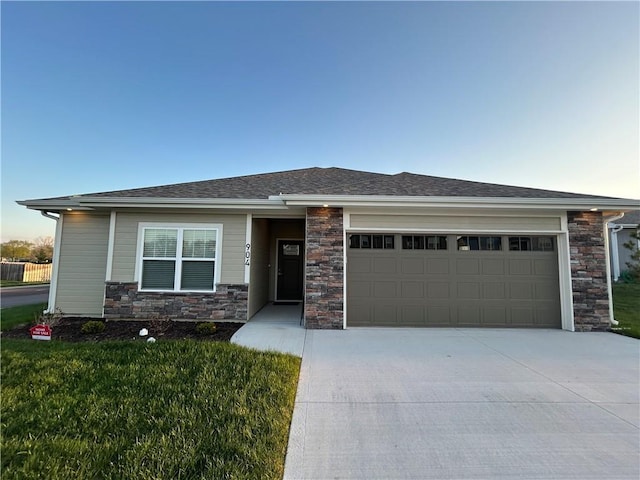 view of front of home featuring a shingled roof, an attached garage, stone siding, concrete driveway, and a front lawn
