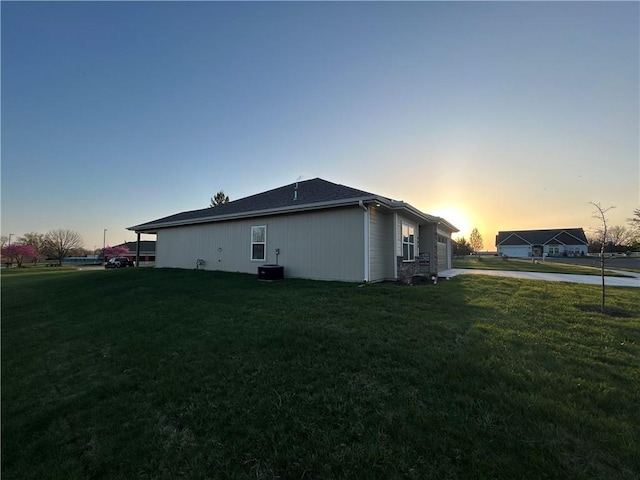view of property exterior featuring an attached garage, concrete driveway, and a lawn