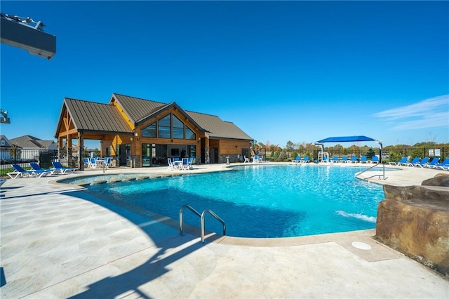 pool with a patio and fence