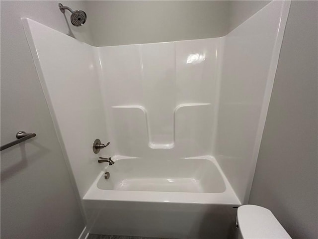 bathroom with toilet and washtub / shower combination