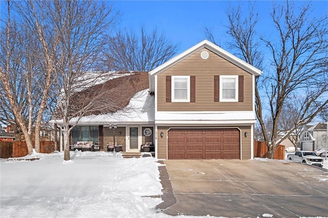 traditional home featuring concrete driveway, fence, and an attached garage