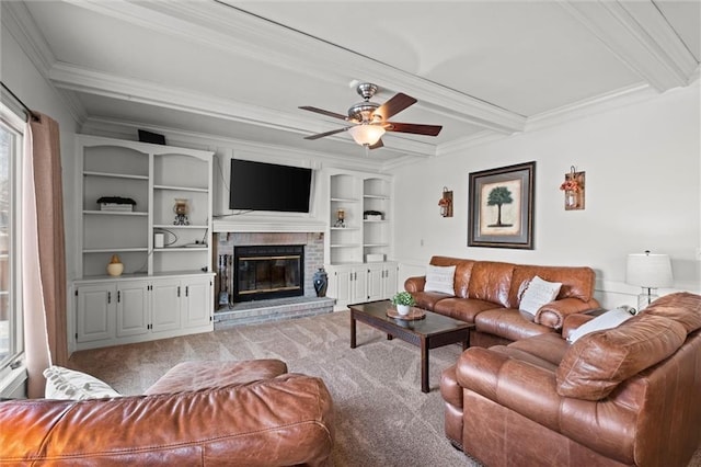 carpeted living room featuring ceiling fan, ornamental molding, a brick fireplace, and beam ceiling