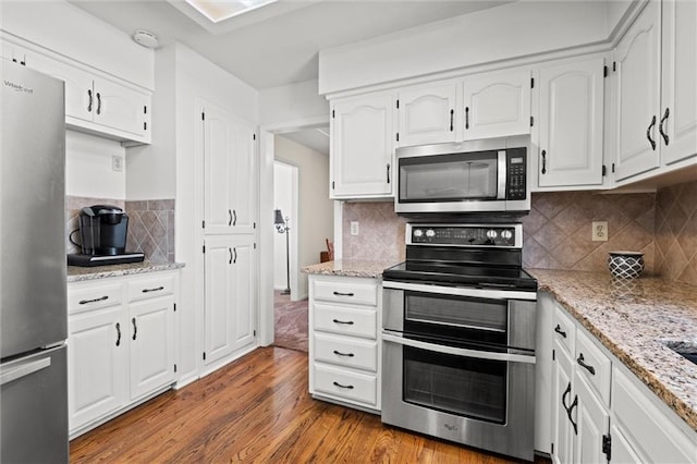 kitchen featuring white cabinetry, stainless steel appliances, and wood finished floors