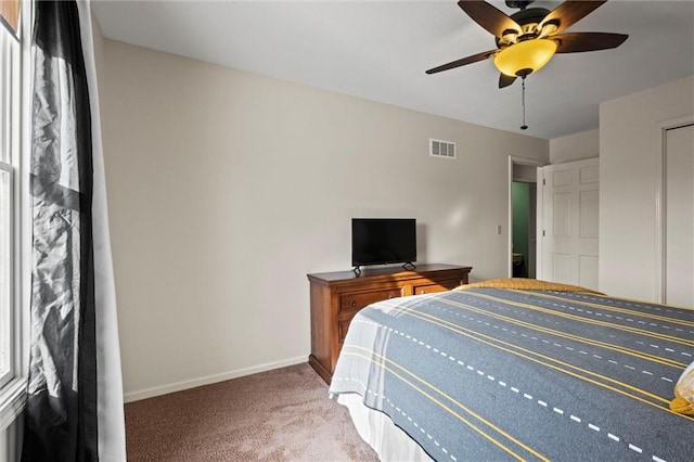 carpeted bedroom with a ceiling fan, visible vents, and baseboards