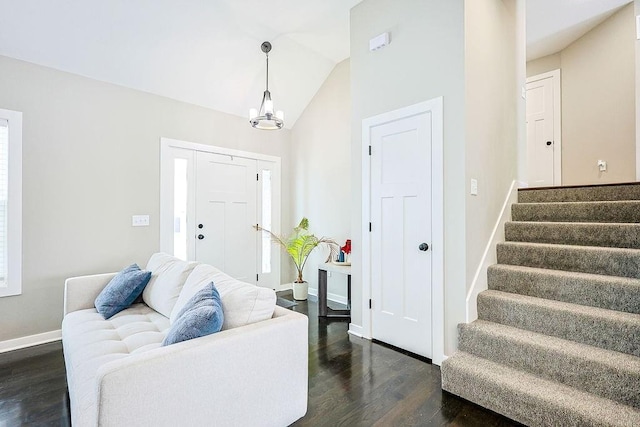 entryway with baseboards, lofted ceiling, dark wood-style floors, stairway, and a notable chandelier