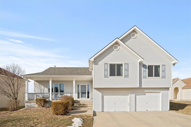 tri-level home featuring a garage, covered porch, and concrete driveway