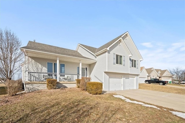 split level home with a porch, a garage, driveway, and a front lawn