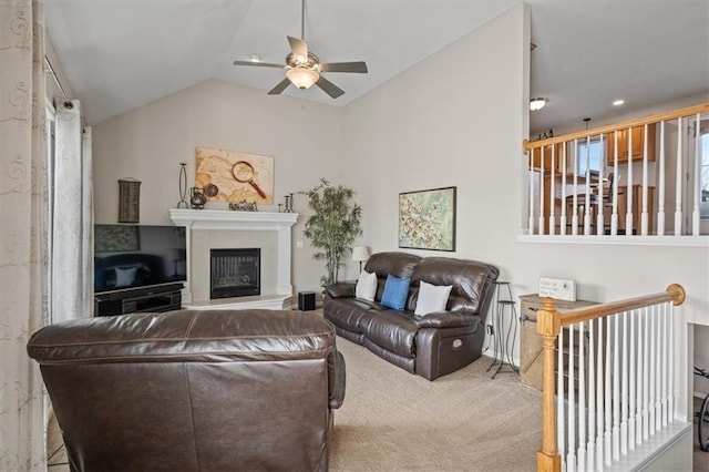 carpeted living area featuring lofted ceiling, ceiling fan, and a glass covered fireplace