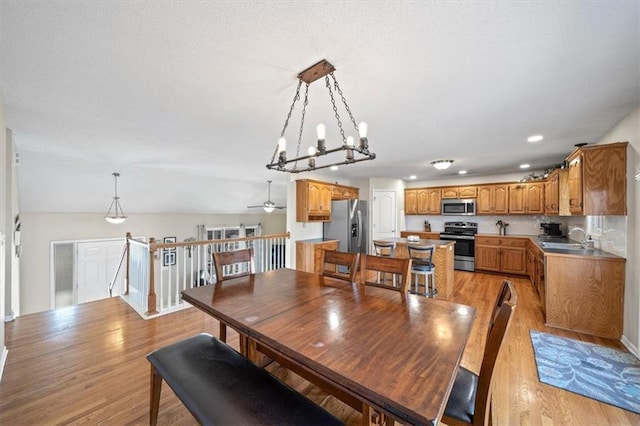 dining area featuring light wood-type flooring, ceiling fan, vaulted ceiling, and recessed lighting