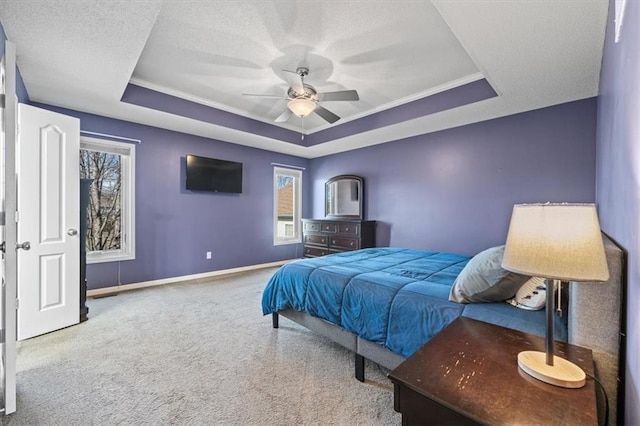 bedroom with light carpet, baseboards, a raised ceiling, and a textured ceiling