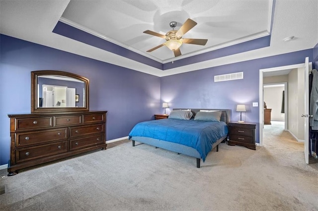 bedroom featuring a raised ceiling, visible vents, light carpet, and baseboards