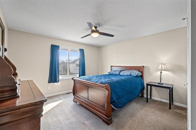 bedroom featuring ceiling fan, baseboards, a textured ceiling, and light colored carpet